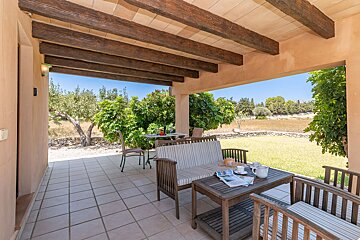 A patio with a couch and a table with a magazine on it