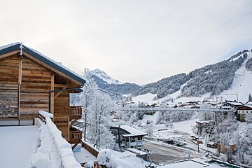 A snowy landscape with a wooden cabin in the foreground