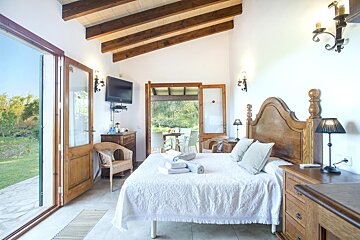 A bedroom with a large bed and a flat screen tv