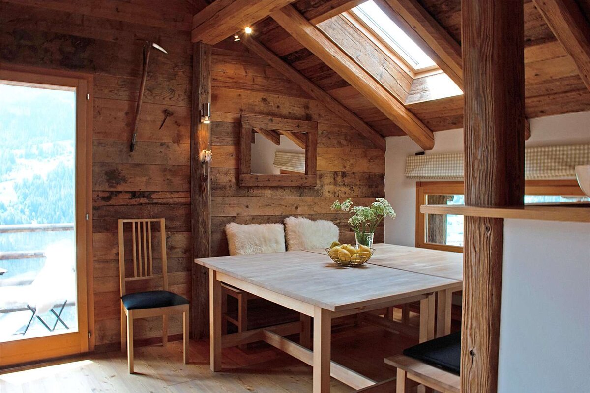 A wooden table with a bowl of lemons on it