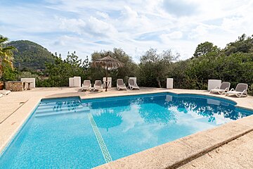 A large swimming pool with chairs and umbrellas around it