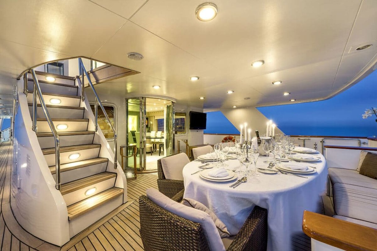 A dining area on a boat with a table and chairs