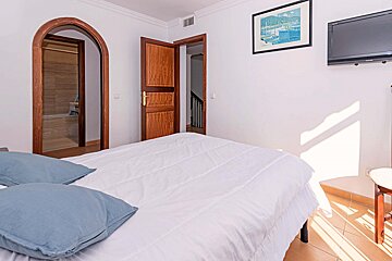 A bedroom with a large bed and a flat screen tv