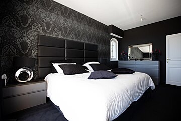 A bedroom with black and white walls and a bed