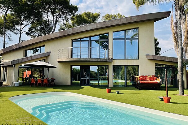 A large house with a swimming pool in front of it