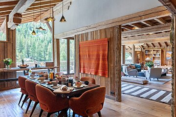 A dining room with a large table and chairs