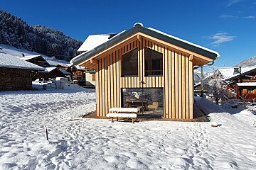 A snowy house with a picnic table in front of it