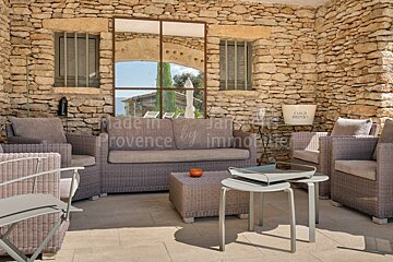 A patio with a couch and chairs and a sign that says