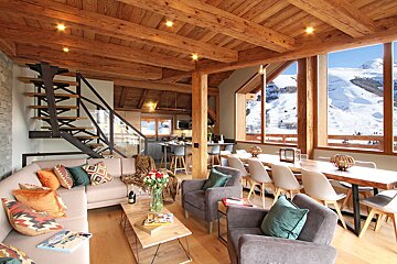A living room with a couch and chairs and a table and chairs