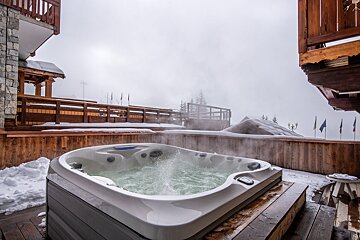 A hot tub with steam coming out of it in the snow