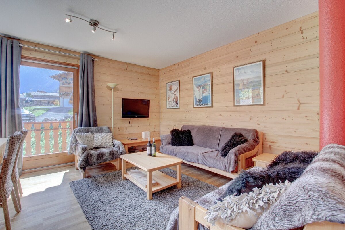 A living room with a couch and two bottles of wine