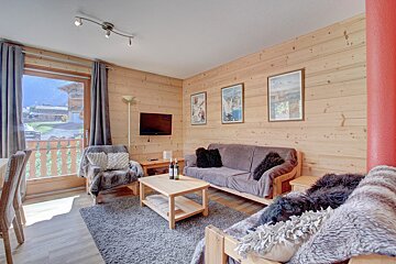 A living room with a couch and two bottles of wine