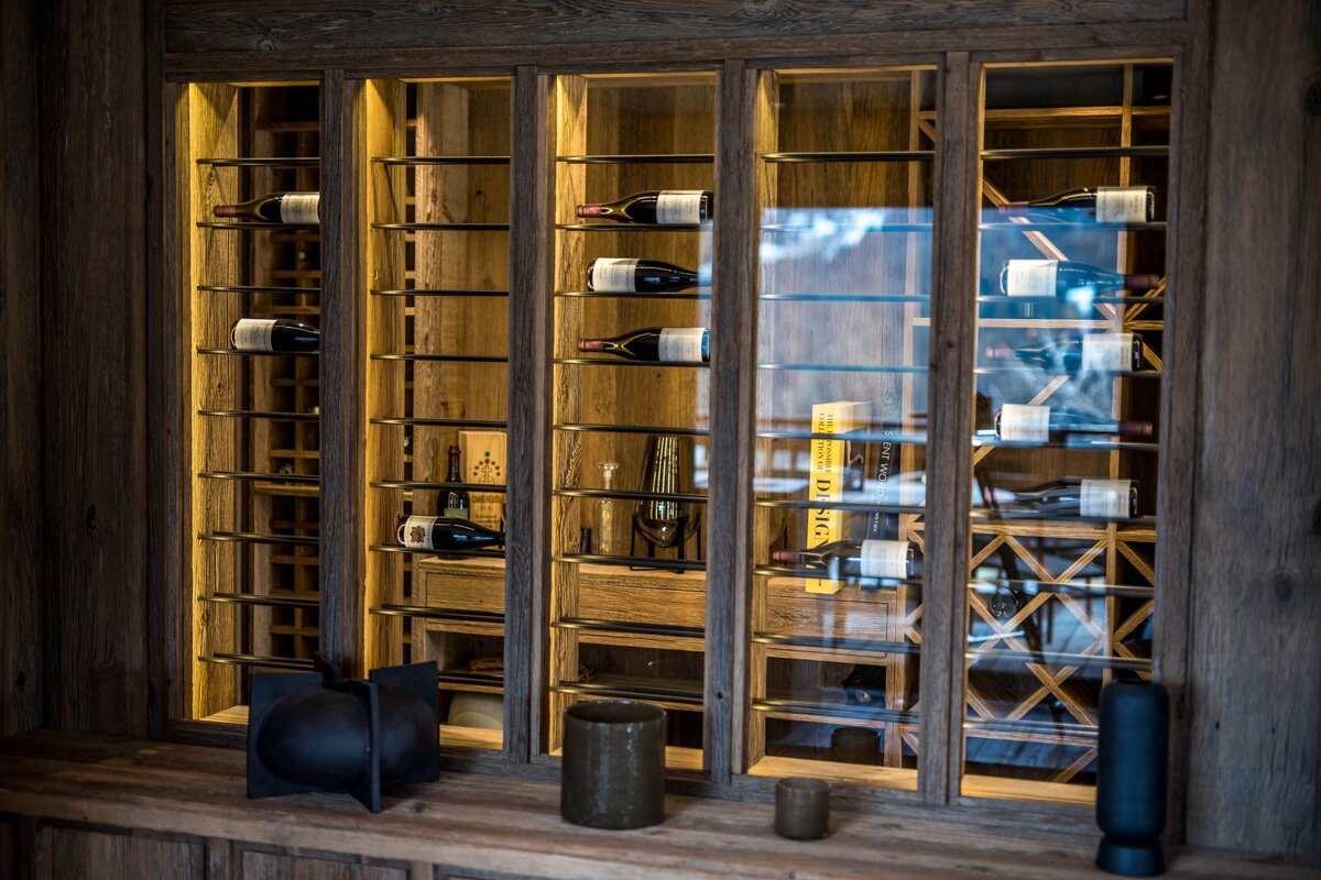 Bottles of wine are displayed in a wine cellar with a yellow book titled 