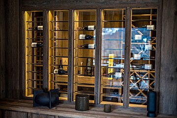 Bottles of wine are displayed in a wine cellar with a yellow book titled 
