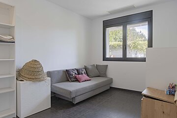 A bedroom with a couch and a window