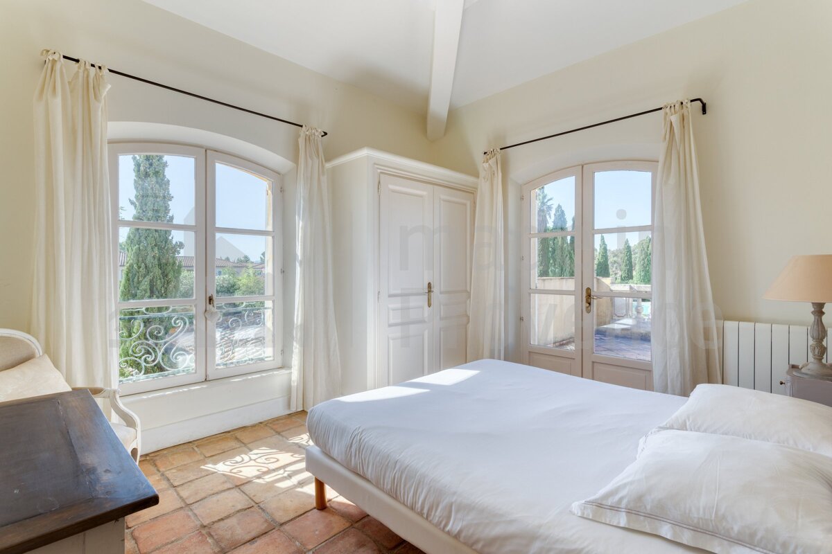 A bedroom with a large bed and a large window