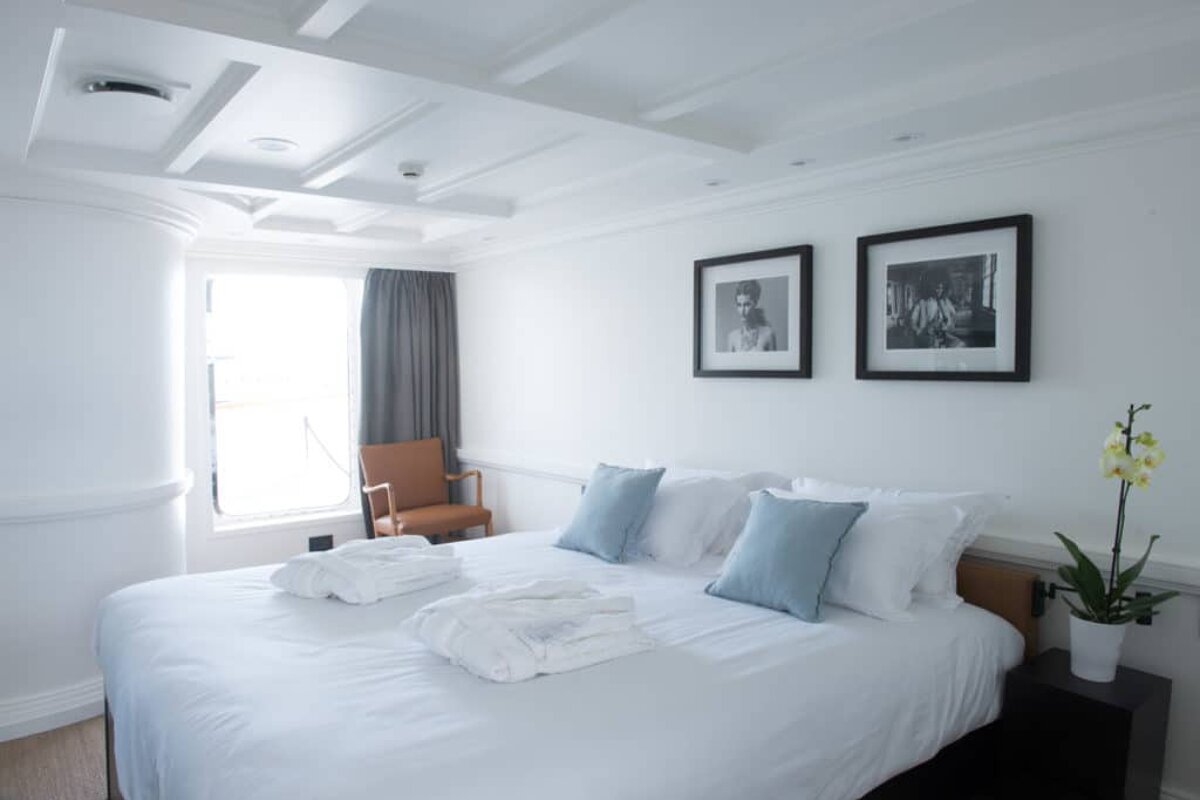 A bedroom with a large bed and two framed pictures on the wall
