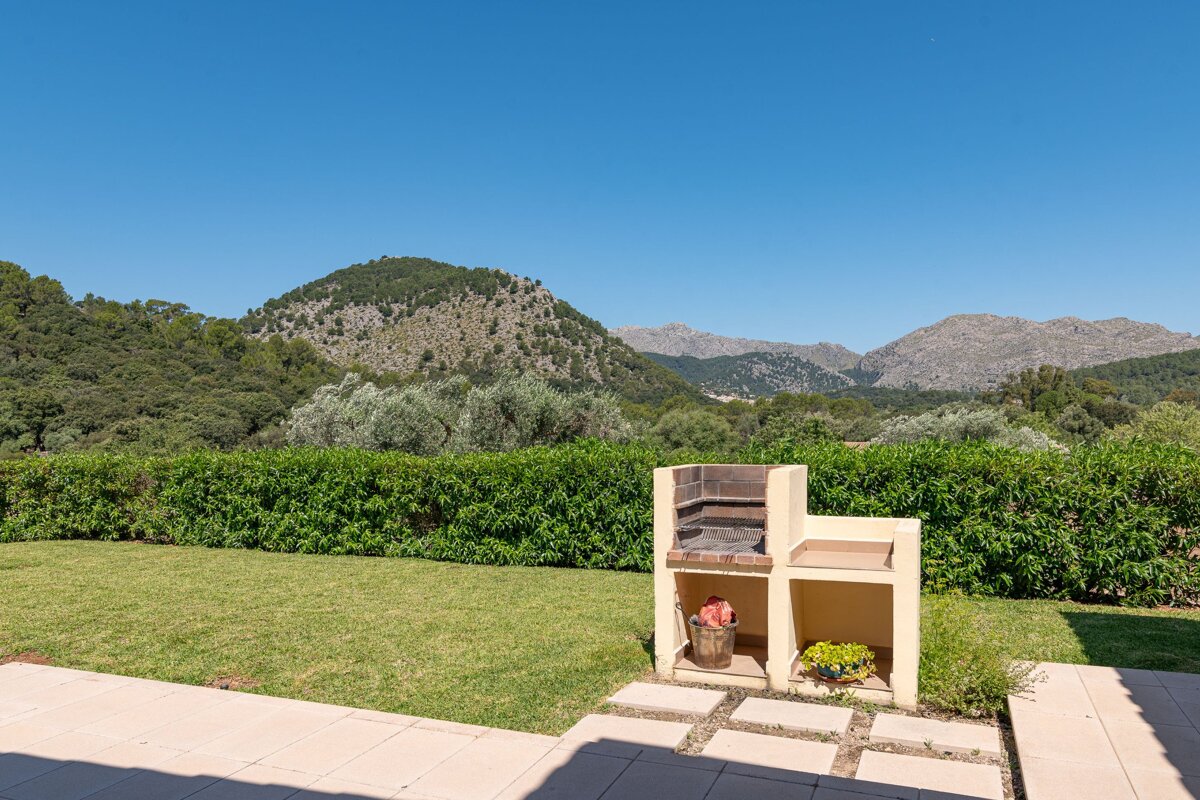 A barbecue grill in a backyard with mountains in the background