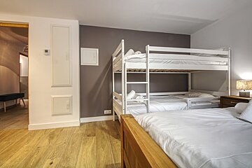 A bedroom with bunk beds and a thermostat on the wall
