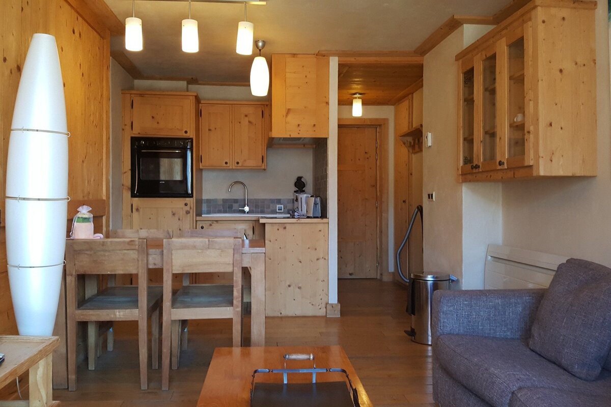 A living room with a table and chairs and a vacuum cleaner
