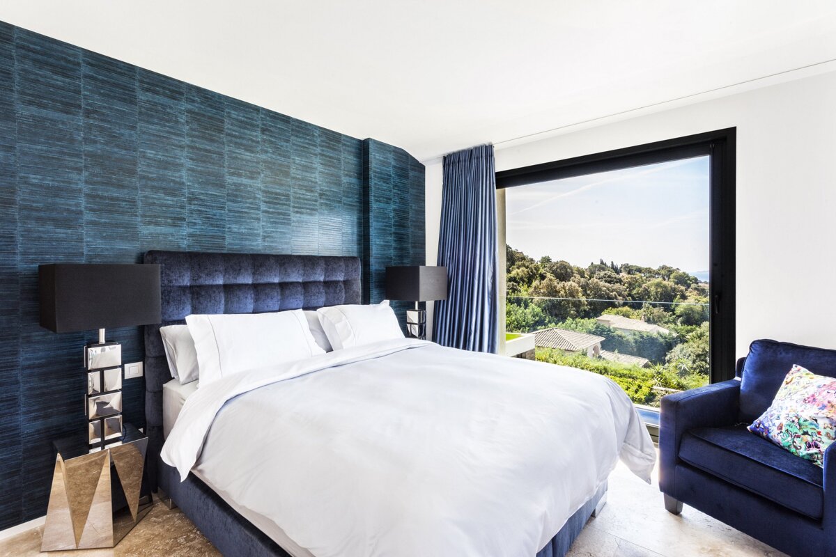 A bedroom with a large bed and a large window