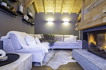 A living room with a fireplace and a sectional couch