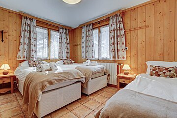 A bedroom with two beds and two lamps