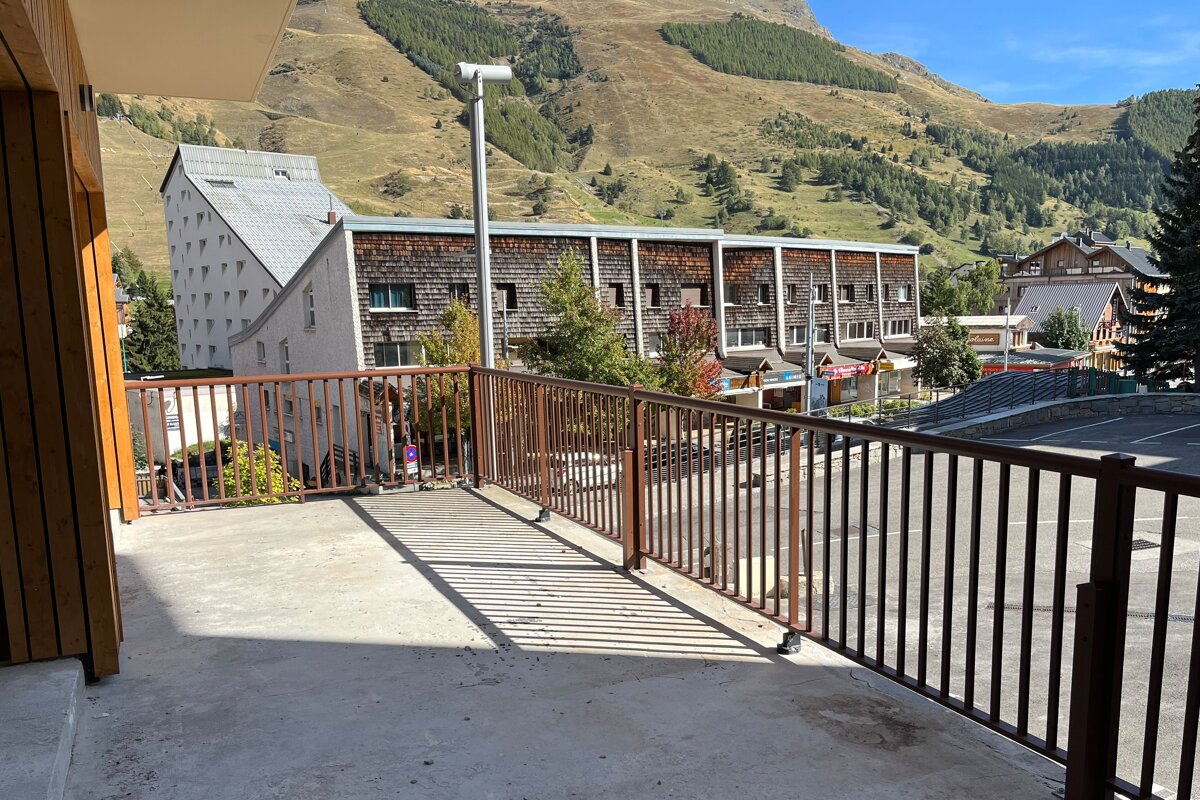 A balcony with a view of a mountain and a building that says ' l' ermitage ' on it