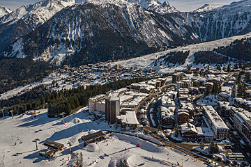 An aerial view of a ski resort with mountains in the background