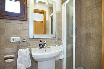 A bathroom with a sink a mirror and a shower