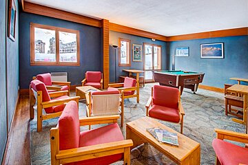 A pool table in a room with chairs and tables