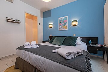 A bedroom with a bed and a picture of a flamingo on the wall