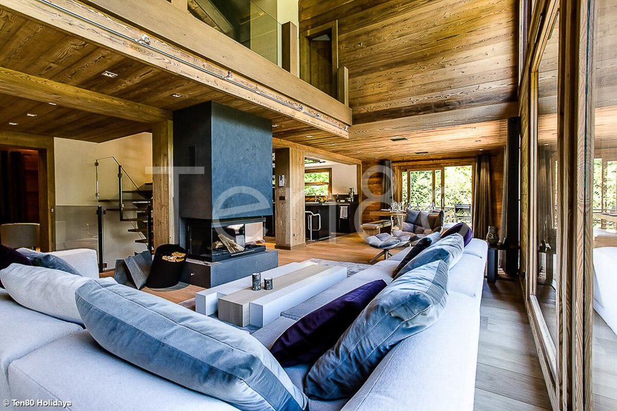 A living room with a couch and a fireplace with the word holidays in the corner