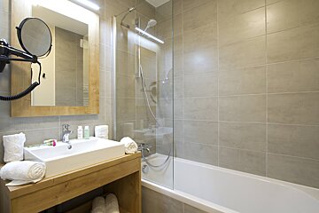 A bathroom with a sink a mirror and a bathtub