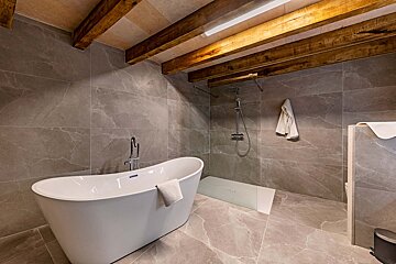 A bathroom with a bathtub and a walk in shower