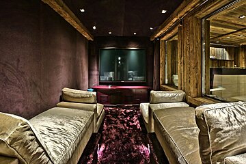A room with purple walls and a flat screen tv