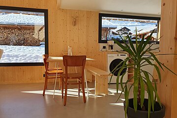 A kitchen with a table and chairs and a washing machine