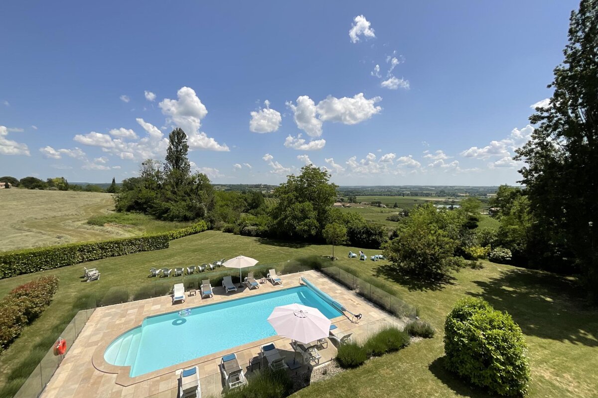 A large swimming pool surrounded by chairs and umbrellas