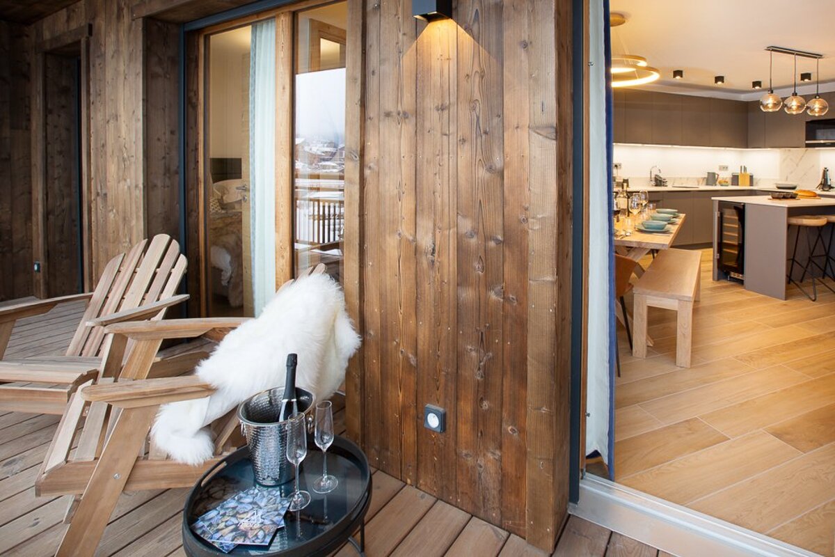 A wooden deck with a chair and a bucket of champagne