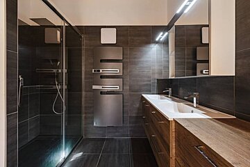 A bathroom with two sinks and a walk in shower