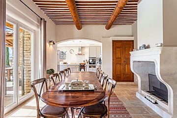 A dining room with a table and chairs and a fireplace
