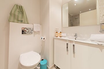 A bathroom with a green bag that says sweet on it