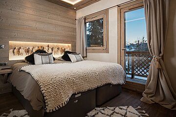 A bedroom with a large bed and a window