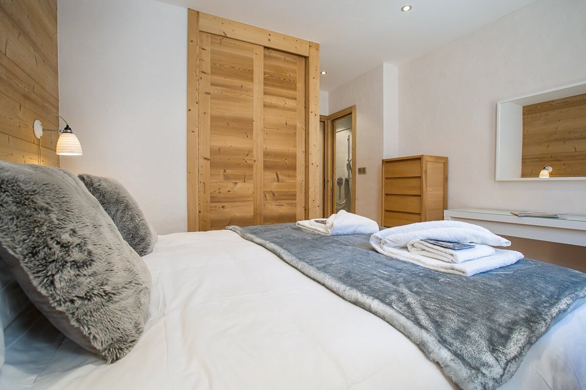 A bedroom with a large bed and a wooden door