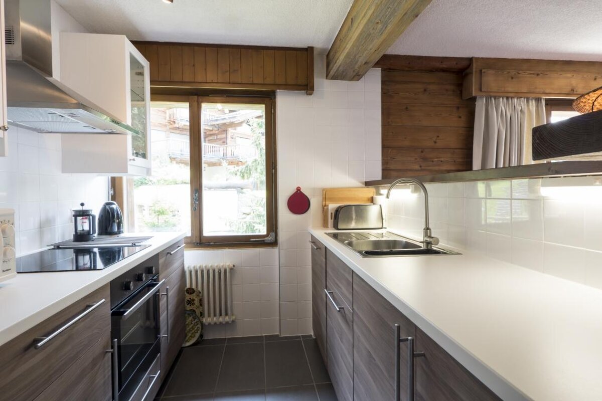 A kitchen with a stove top oven and a sink