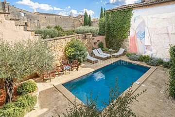 A large swimming pool is surrounded by chairs and a table with the word immobilier on it