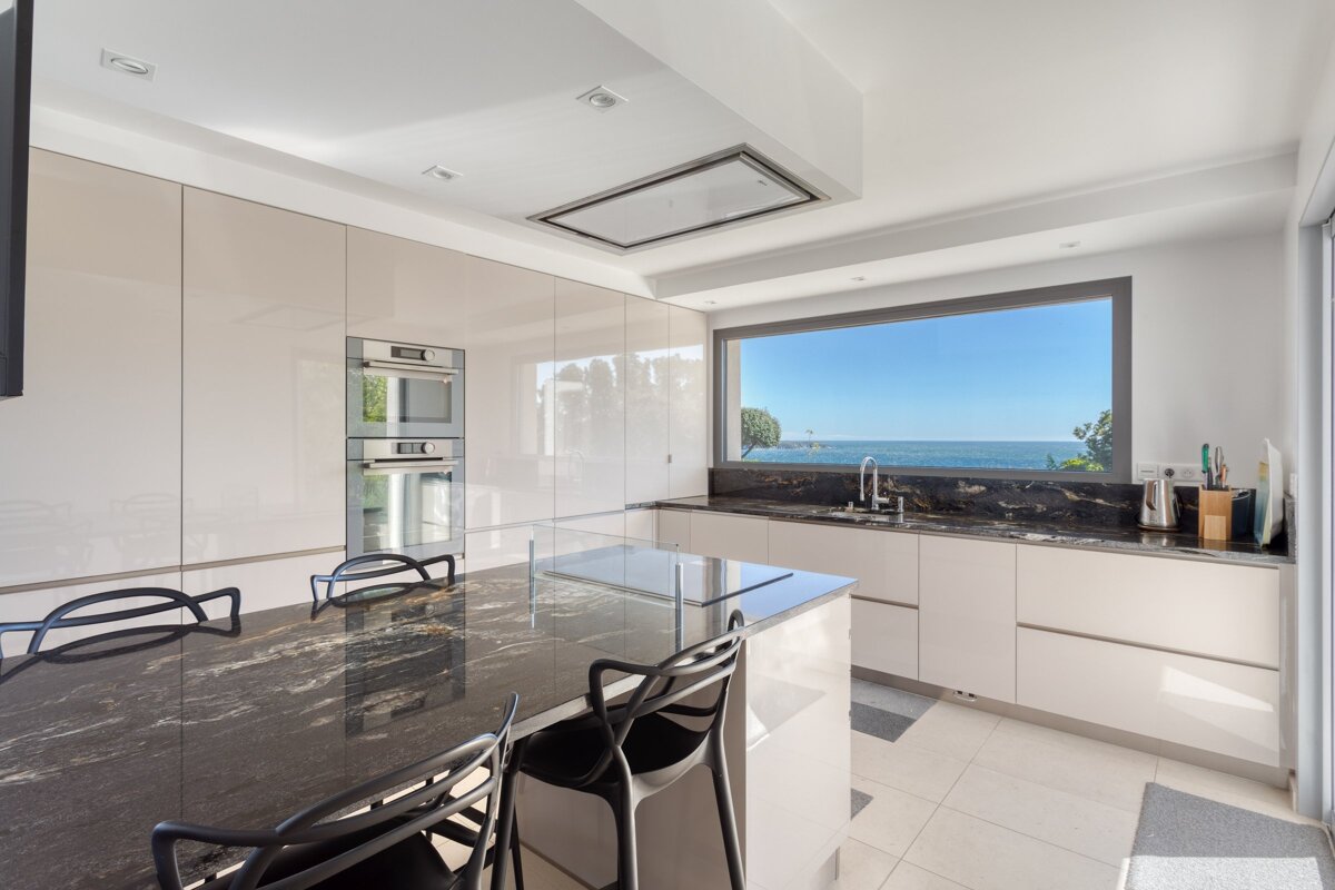 A kitchen with a large window overlooking the ocean
