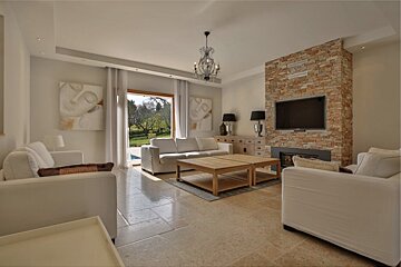 A living room with a stone fireplace and a flat screen tv