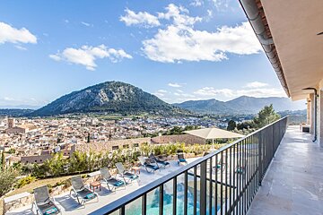 A balcony overlooking a city with a mountain in the background
