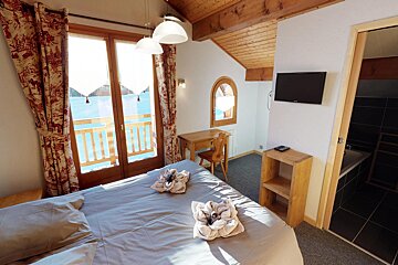 A bedroom with a large bed and a flat screen tv